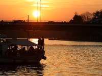 A boat floats on the Vistula River at sunset in Krakow, Poland, on October 27, 2024. (