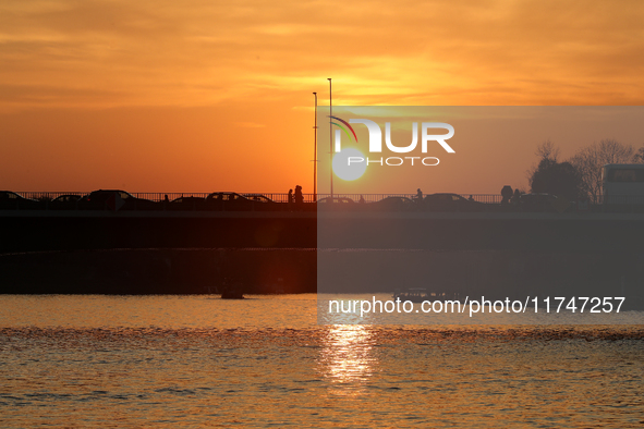 A bridge with cars is on the Vistula River at sunset in Krakow, Poland, on October 27, 2024. 