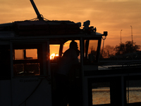 A boat floats on the Vistula River at sunset in Krakow, Poland, on October 27, 2024. (