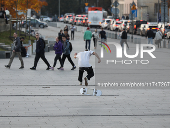 People skateboard on the square in Krakow, Poland, on October 27, 2024. (