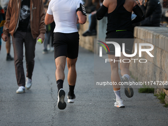 People run on the boulevards along the Vistula River in Krakow, Poland, on October 27, 2024. (