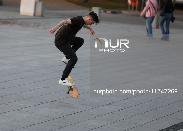 People skateboard on the square in Krakow, Poland, on October 27, 2024. 