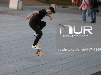 People skateboard on the square in Krakow, Poland, on October 27, 2024. (