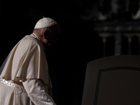 Pope Francis enters a shadowed area, using his walking stick, and arrives to attend the weekly general audience at St. Peter's Square in The...