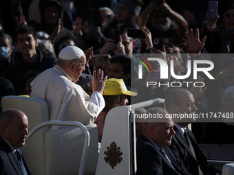 Pope Francis waves to pilgrims after attending the weekly general audience at St. Peter's Square in The Vatican on November 6, 2024. (