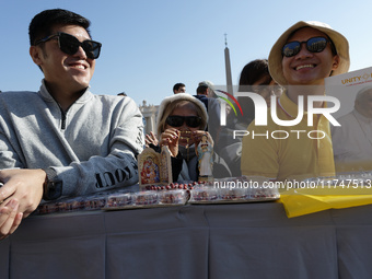 A group of faithful shows rosaries and an image of the Virgin Lady during the general audience of Pope Francis in St. Peter's Square, at the...