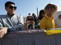 A group of faithful shows rosaries and an image of the Virgin Lady during the general audience of Pope Francis in St. Peter's Square, at the...