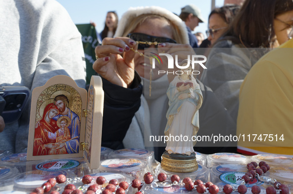 A group of faithful shows rosaries and an image of the Virgin Lady during the general audience of Pope Francis in St. Peter's Square, at the...