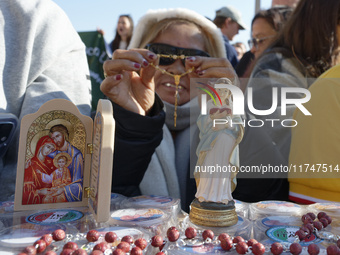 A group of faithful shows rosaries and an image of the Virgin Lady during the general audience of Pope Francis in St. Peter's Square, at the...