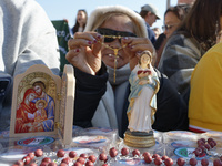 A group of faithful shows rosaries and an image of the Virgin Lady during the general audience of Pope Francis in St. Peter's Square, at the...