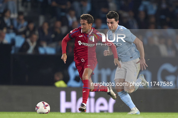 Anastasios Douvikas of RC Celta de Vigo competes for the ball with Luis Milla of Getafe CF during the La Liga EA Sports match between RC Cel...