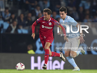 Anastasios Douvikas of RC Celta de Vigo competes for the ball with Luis Milla of Getafe CF during the La Liga EA Sports match between RC Cel...