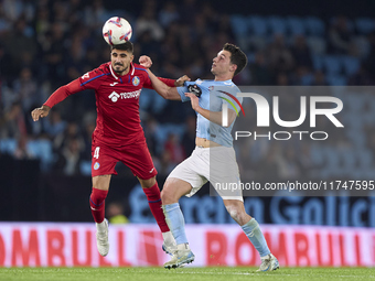 Anastasios Douvikas of RC Celta de Vigo competes for the ball with Juan Berrocal of Getafe CF during the La Liga EA Sports match between RC...