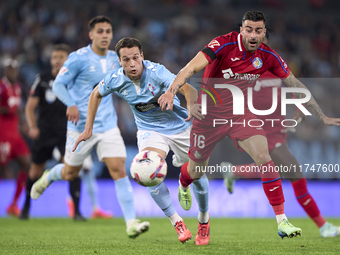 Javier Manquillo of RC Celta de Vigo competes for the ball with Diego Rico of Getafe CF during the La Liga EA Sports match between RC Celta...