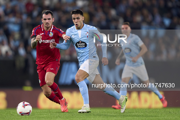 Alex Sola of Getafe CF competes for the ball with Hugo Sotelo of RC Celta de Vigo during the La Liga EA Sports match between RC Celta de Vig...