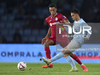 Alvaro Rodriguez of Getafe CF competes for the ball with Hugo Sotelo of RC Celta de Vigo during the La Liga EA Sports match between RC Celta...