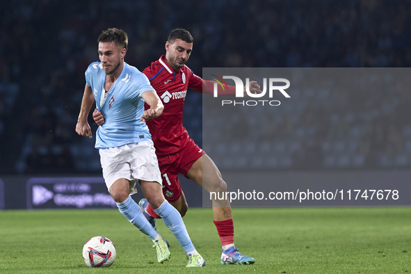 Juan Iglesias of Getafe CF competes for the ball with Oscar Mingueza of RC Celta de Vigo during the La Liga EA Sports match between RC Celta...