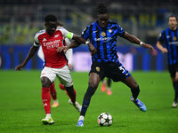 Bukayo Saka of Arsenal and Yann Aurel Bisseck of Inter Milan battle for the ball during the Champions League match between Inter Milan and A...