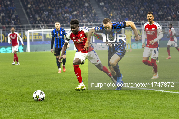 Bukayo Saka and Piotr Zielinski play during the UEFA Champions League 2024/25 match between FC Internazionale and FC Arsenal at Stadio Giuse...