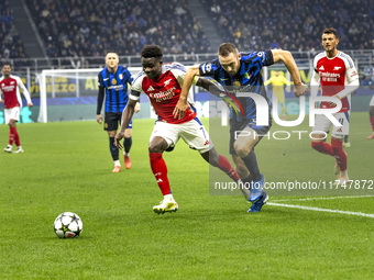 Bukayo Saka and Piotr Zielinski play during the UEFA Champions League 2024/25 match between FC Internazionale and FC Arsenal at Stadio Giuse...