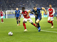 Bukayo Saka and Piotr Zielinski play during the UEFA Champions League 2024/25 match between FC Internazionale and FC Arsenal at Stadio Giuse...