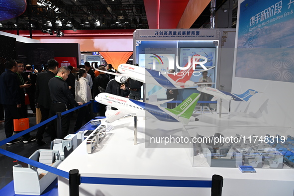 Visitors view models of C919 and C929 aircraft at the China Pavilion during the 7th China International Import Expo in Shanghai, China, on N...