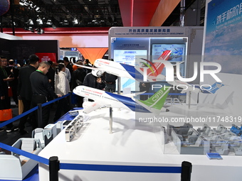 Visitors view models of C919 and C929 aircraft at the China Pavilion during the 7th China International Import Expo in Shanghai, China, on N...