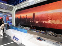 Visitors watch a video on the construction of the Shenzhen-China Corridor at the China Pavilion during the 7th China International Import Ex...