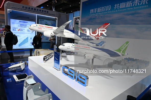 Visitors view models of C919 and C929 aircraft at the China Pavilion during the 7th China International Import Expo in Shanghai, China, on N...