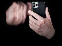 A close-up of a hand swipes on a smartphone screen, creating a motion blur effect that symbolizes the fast-paced nature of digital interacti...