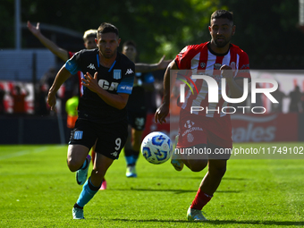 Adrian Martinez of Racing Club competes for the ball against Nicolas Tolosa of Barracas Central during a Liga Profesional 2024 match between...