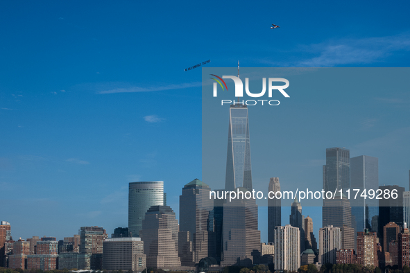 A small plane towing a sign that reads ''We hold democracy together'' flies over New York, U.S., on November 6, 2024. 