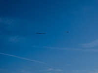 A small plane towing a sign that reads ''We hold democracy together'' flies over New York, U.S., on November 6, 2024. (