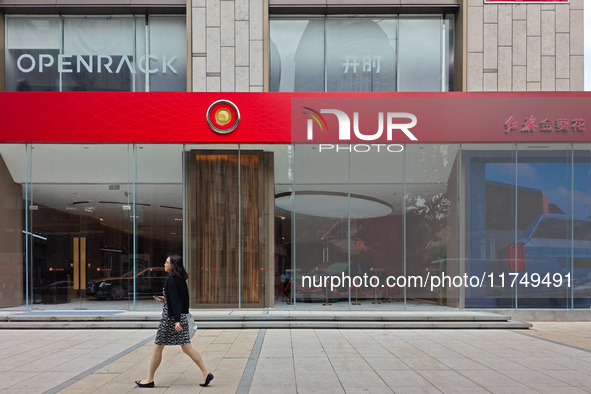 A pedestrian passes a Hongqi car dealership in Shanghai, China, on November 7, 2024. 