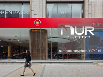 A pedestrian passes a Hongqi car dealership in Shanghai, China, on November 7, 2024. (