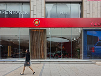 A pedestrian passes a Hongqi car dealership in Shanghai, China, on November 7, 2024. (