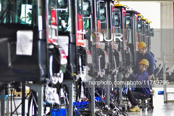 Workers assemble a cab at a loader manufacturing enterprise at Yunmenshan Street in Qingzhou, China, on October 31, 2024. On the same day, t...