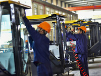 Workers assemble a cab at a loader manufacturing enterprise at Yunmenshan Street in Qingzhou, China, on October 31, 2024. On the same day, t...