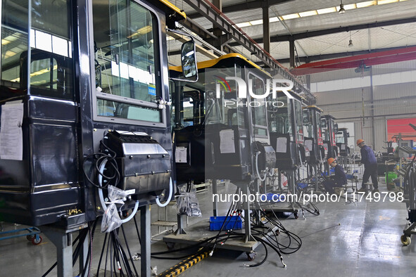 Workers assemble a cab at a loader manufacturing enterprise at Yunmenshan Street in Qingzhou, China, on October 31, 2024. On the same day, t...