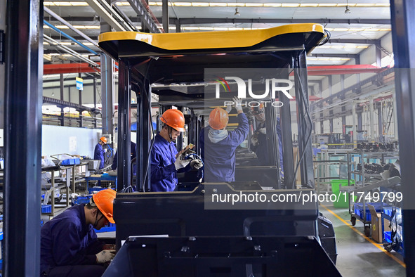 Workers assemble a cab at a loader manufacturing enterprise at Yunmenshan Street in Qingzhou, China, on October 31, 2024. On the same day, t...