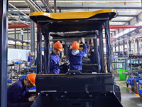 Workers assemble a cab at a loader manufacturing enterprise at Yunmenshan Street in Qingzhou, China, on October 31, 2024. On the same day, t...