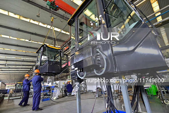 Workers assemble a cab at a loader manufacturing enterprise at Yunmenshan Street in Qingzhou, China, on October 31, 2024. On the same day, t...