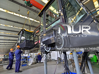 Workers assemble a cab at a loader manufacturing enterprise at Yunmenshan Street in Qingzhou, China, on October 31, 2024. On the same day, t...