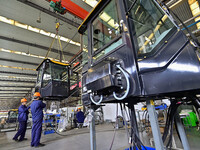 Workers assemble a cab at a loader manufacturing enterprise at Yunmenshan Street in Qingzhou, China, on October 31, 2024. On the same day, t...