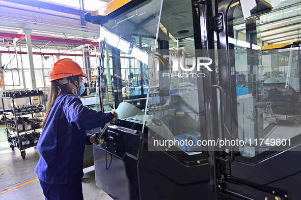 Workers assemble a cab at a loader manufacturing enterprise at Yunmenshan Street in Qingzhou, China, on October 31, 2024. On the same day, t...