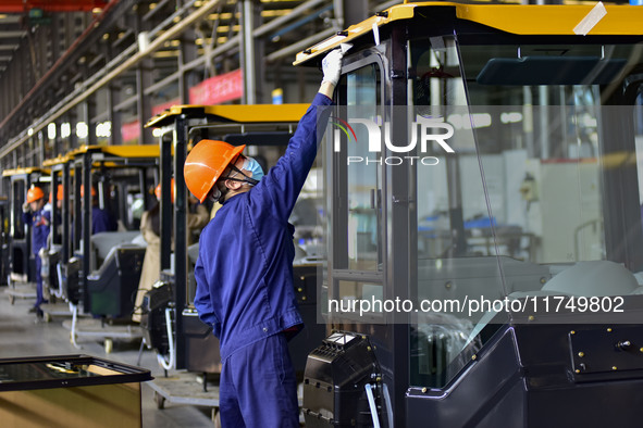 Workers assemble a cab at a loader manufacturing enterprise at Yunmenshan Street in Qingzhou, China, on October 31, 2024. On the same day, t...