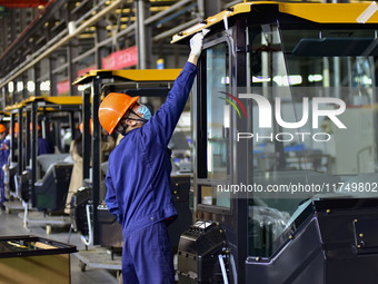 Workers assemble a cab at a loader manufacturing enterprise at Yunmenshan Street in Qingzhou, China, on October 31, 2024. On the same day, t...