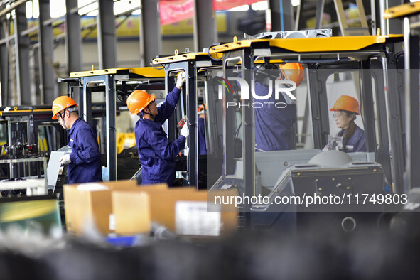 Workers assemble a cab at a loader manufacturing enterprise at Yunmenshan Street in Qingzhou, China, on October 31, 2024. On the same day, t...