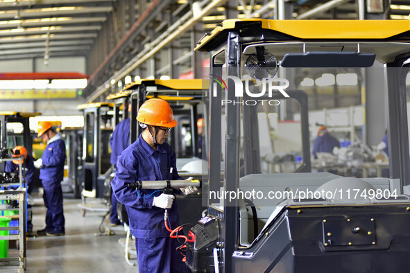 Workers assemble a cab at a loader manufacturing enterprise at Yunmenshan Street in Qingzhou, China, on October 31, 2024. On the same day, t...