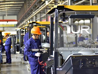 Workers assemble a cab at a loader manufacturing enterprise at Yunmenshan Street in Qingzhou, China, on October 31, 2024. On the same day, t...